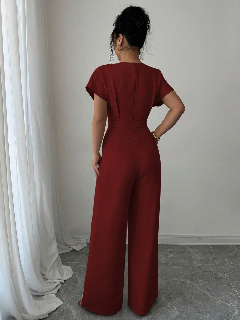 Mono largo burdeos elegante de manga murciélago con escote en V vista frontal.
