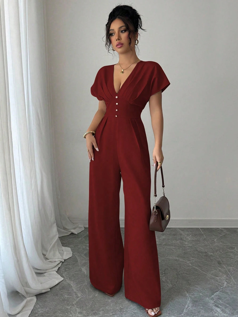 Mono largo burdeos elegante de manga murciélago con escote en V vista frontal.
