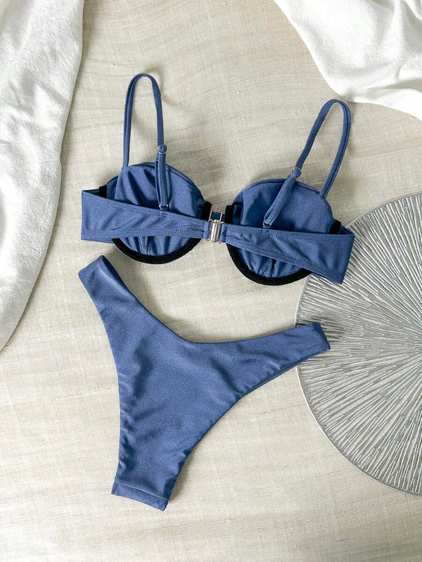 Top de bikini azul marino con detalle de aro dorado y fruncido.