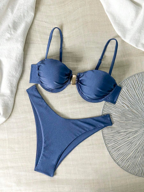 Bikini azul marino con top fruncido y aro dorado en V, y braguita cheeky de corte alto.
