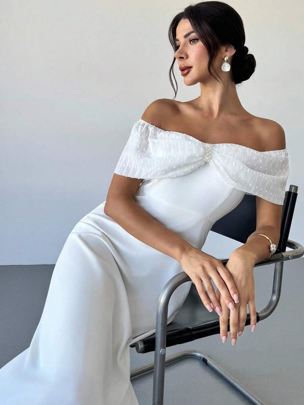 Mujer luciendo vestido blanco elegante en estilo formal.
