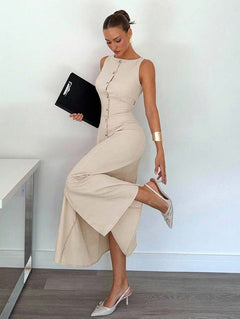 Modelo posando con vestido midi beige sin mangas abotonado de estilo elegante y formal.
