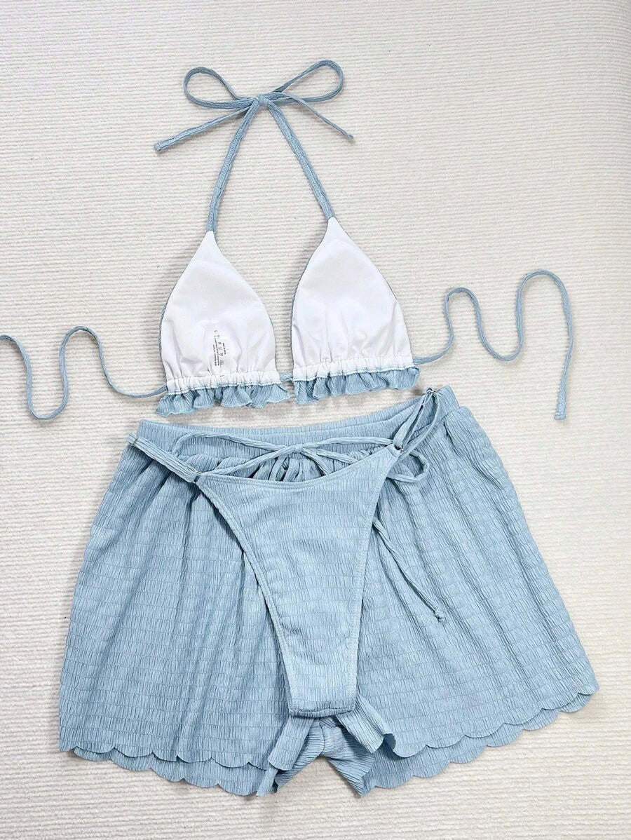 Vista frontal de un conjunto de dos piezas color celeste con textura arrugada, compuesto por un top halter y shorts.