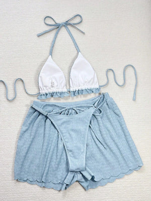 Detalle del top halter de un conjunto de playa, mostrando el escote en V y la tela texturizada.