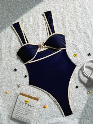 Primer plano del torso con el traje de baño azul marino, destacando el recorte y el adorno de estrella de mar.