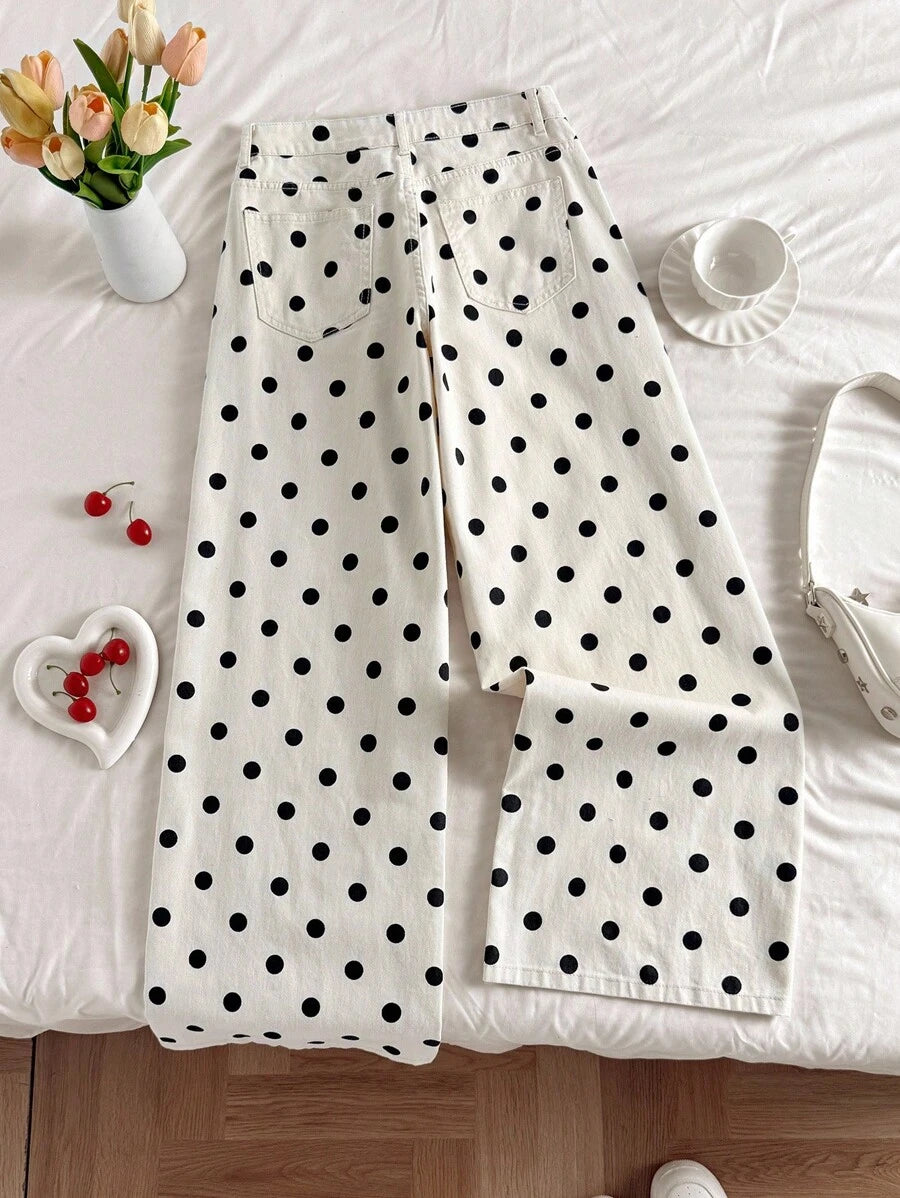 Vista del bajo de los pantalones de pierna ancha con lunares sostenidos por una mano.