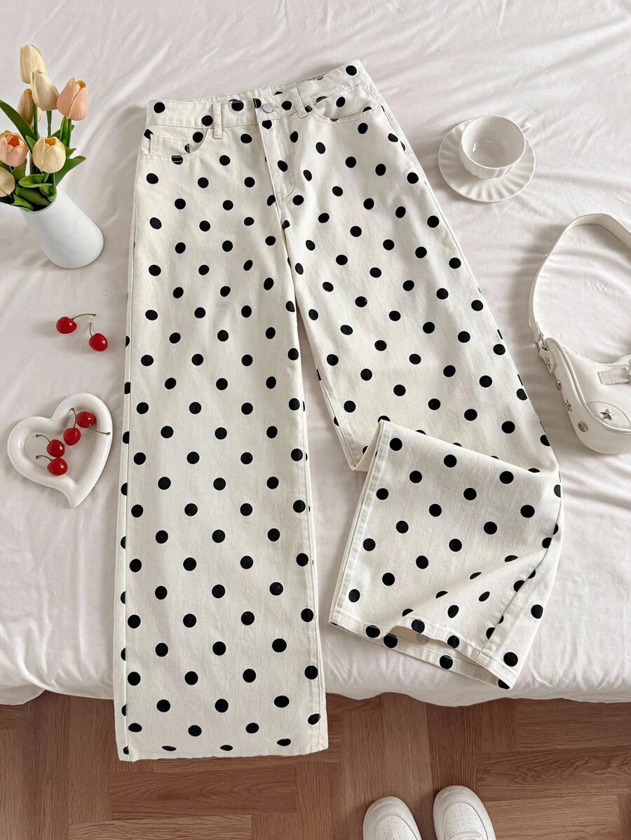 Vista del bajo de los pantalones de pierna ancha con lunares sostenidos por una mano.