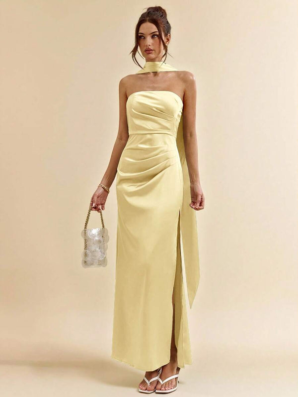 Vista lateral de la falda de un vestido satinado amarillo mostrando la abertura y el tejido.