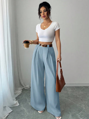 Modelo combinando pantalón azul casual con bolso y top