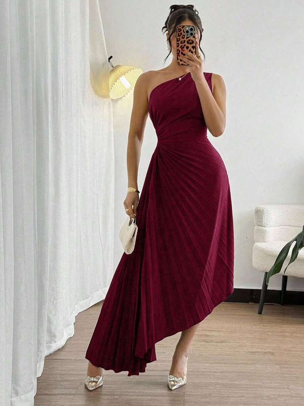 Detalle del movimiento y la caída de la falda plisada asimétrica del vestido de fiesta.