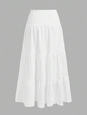 Falda larga blanca con capas y talle alto, vista trasera.