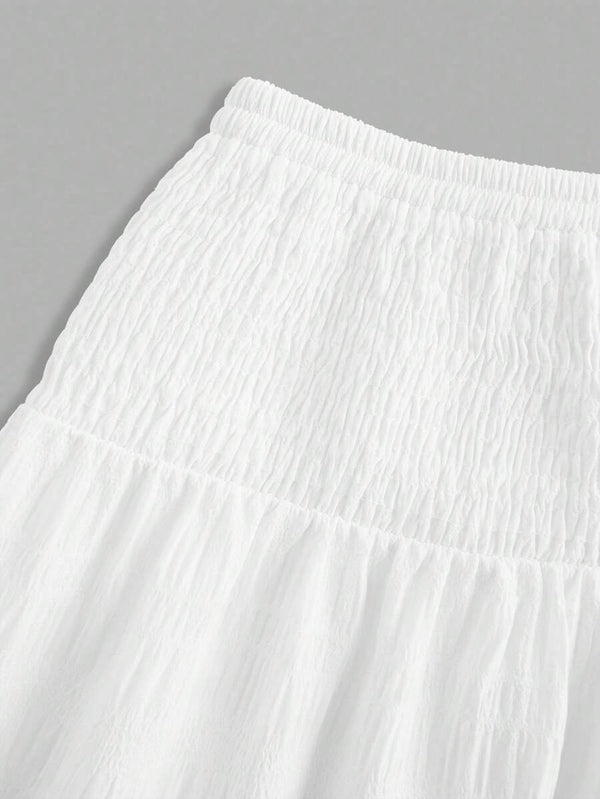 Detalle de la cintura fruncida de la falda larga blanca.