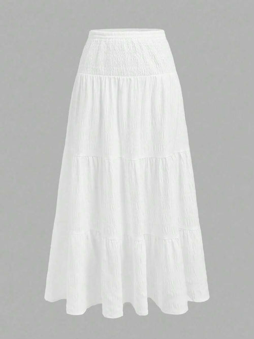 Falda larga blanca con capas y talle alto, vista frontal.