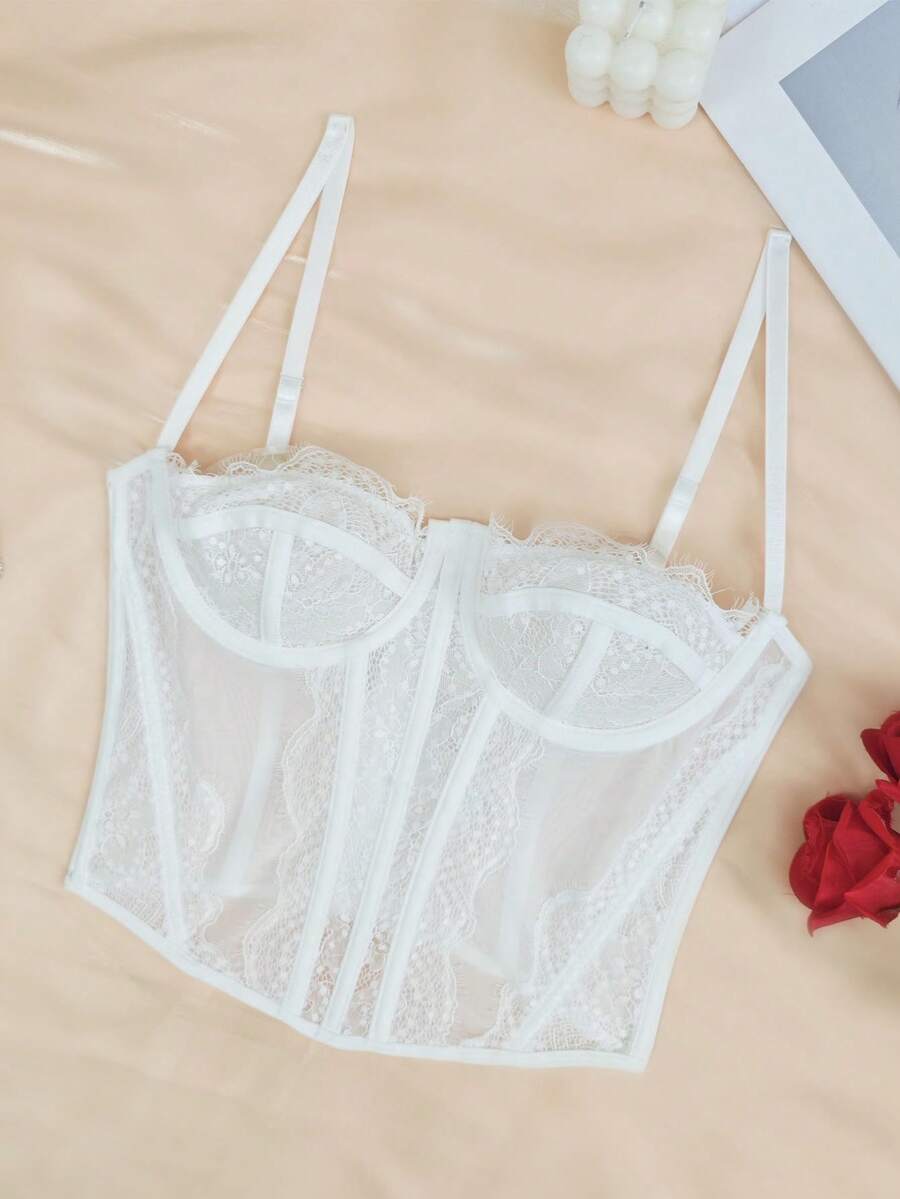 Vista frontal de top corset de encaje blanco con tirantes ajustables.