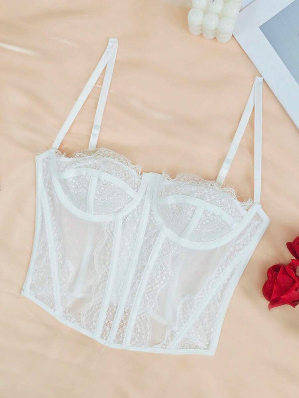 Detalle del escote corazón y las copas de encaje del bustier blanco.
