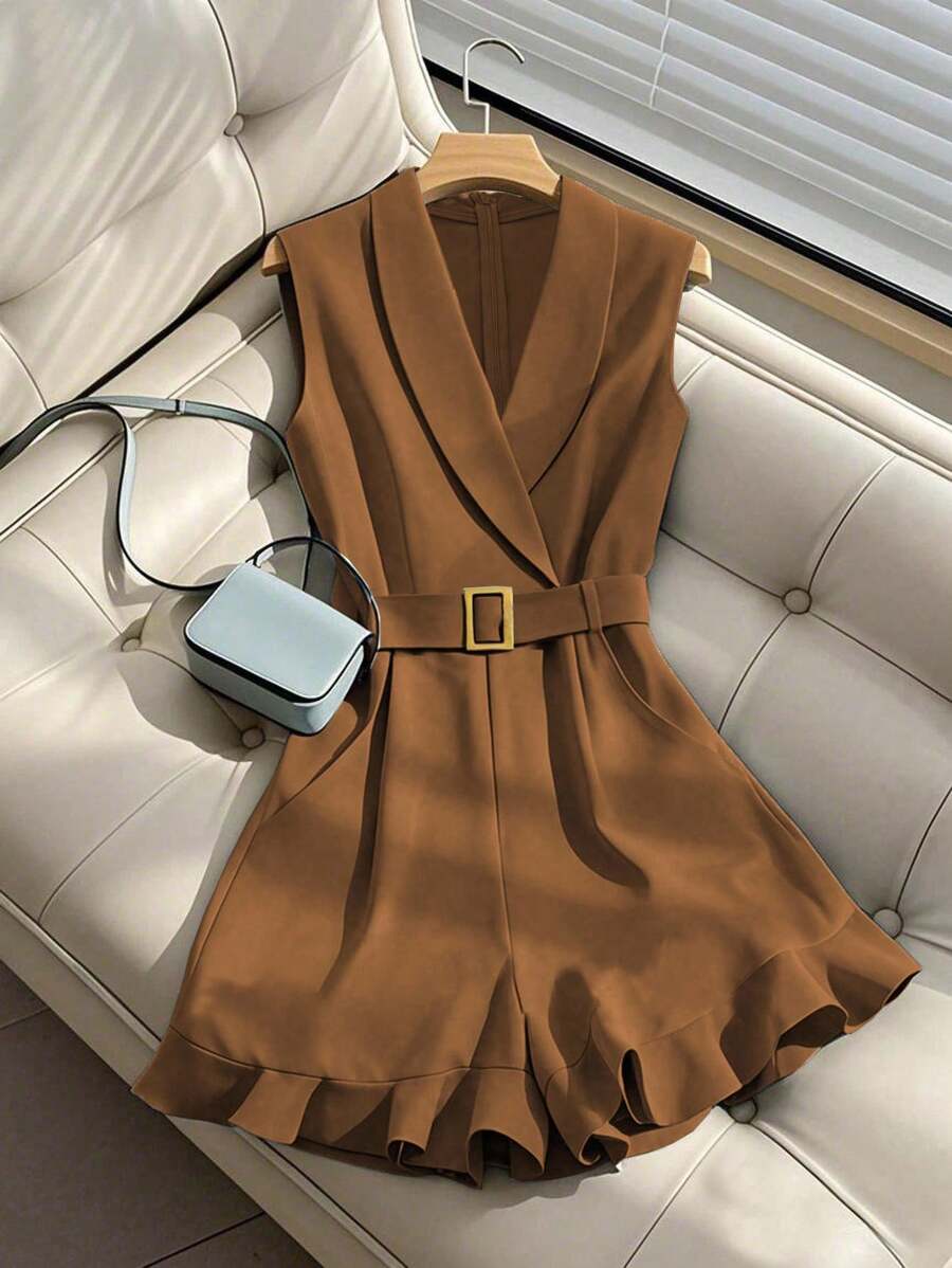 Romper elegante color café sin mangas con cuello de solapa y cinturón, visto desde arriba sobre un sofá.