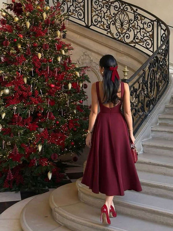 Vista inferior mostrando el largo midi y la caída de la falda de un vestido color vino.