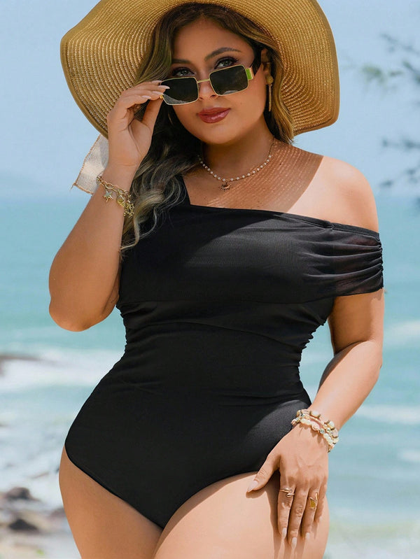 Traje De Baño Enterizo Negro Asimétrico detalle del escote y manga con malla.