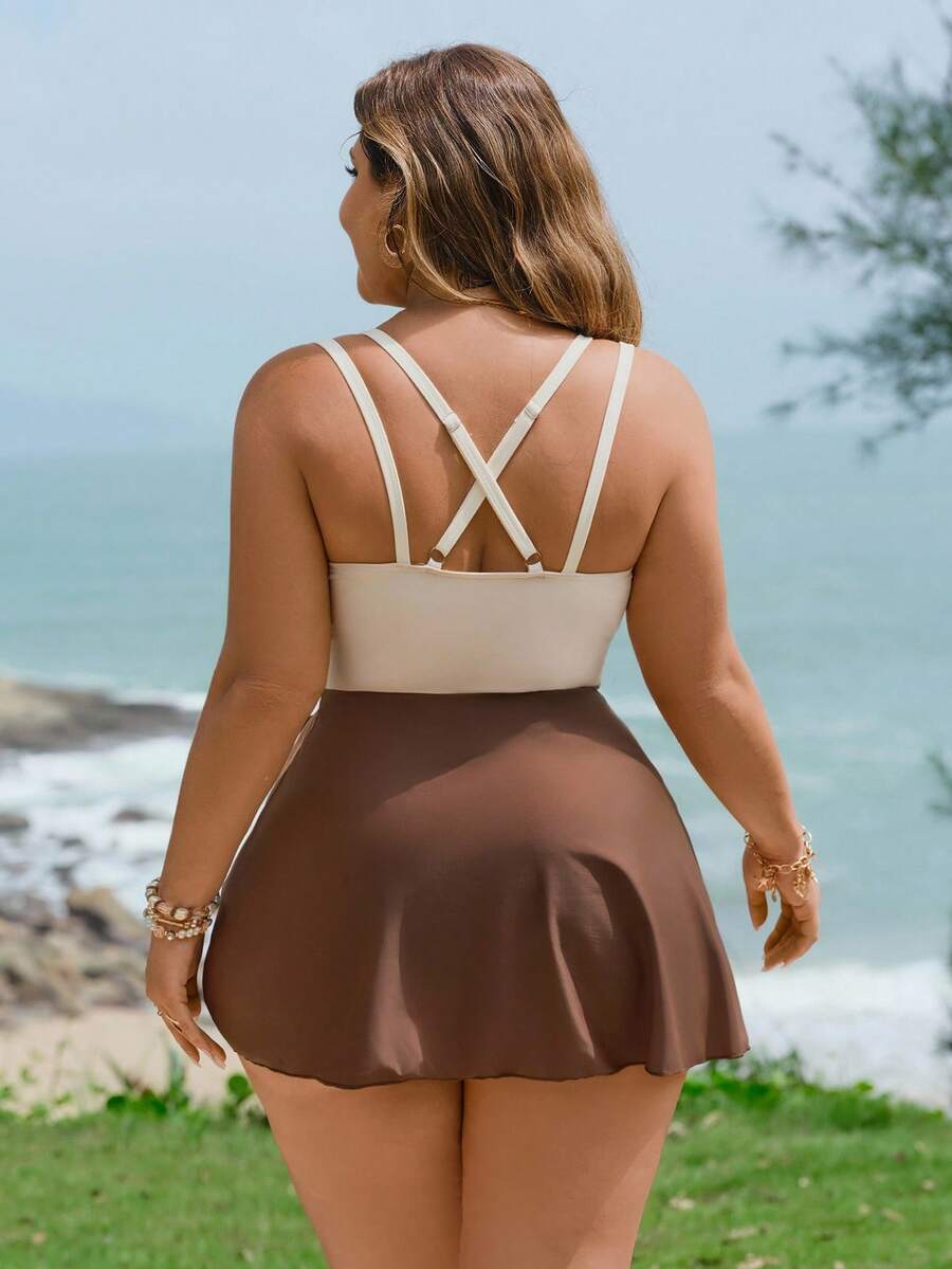 Mujer de talla grande posando en la playa con un traje de baño de una pieza tricolor con falda café y escote v.
