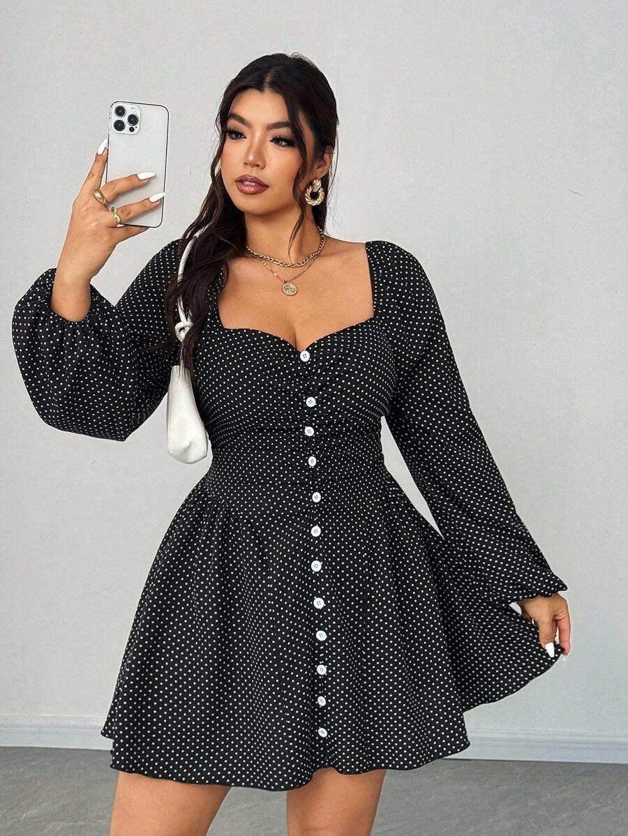 Mujer posando de frente con un vestido negro corto de lunares blancos, escote corazón y mangas largas abullonadas.