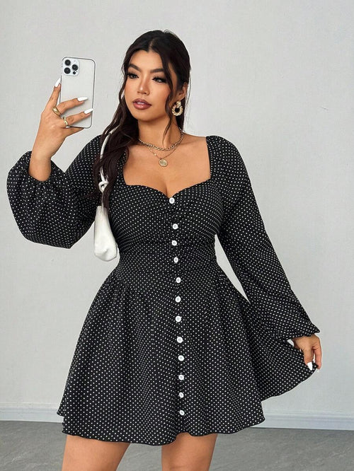 Mujer posando de frente con un vestido negro corto de lunares blancos, escote corazón y mangas largas abullonadas.
