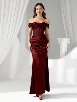 Vista completa de una modelo luciendo un vestido de satén borgoña con escote corazón.