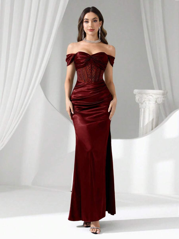 Vista completa de una modelo luciendo un vestido de satén borgoña con escote corazón.
