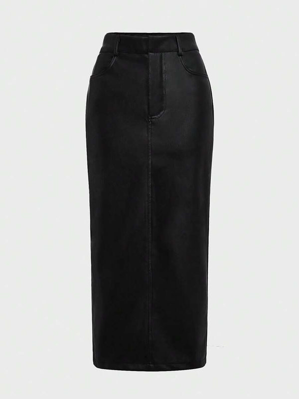 Primer plano del atuendo con una falda midi de cuero sintético negra de talle alto y una blusa blanca.