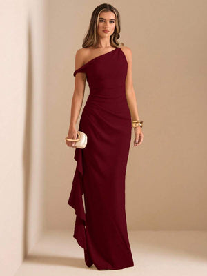 Vista frontal de un vestido de fiesta largo color burdeos con diseño de un solo hombro y volante lateral.