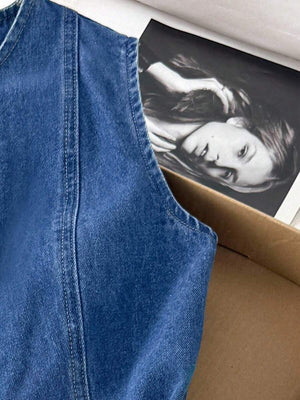 Vista lateral superior del vestido de mezclilla mostrando la sisa y los botones dorados.