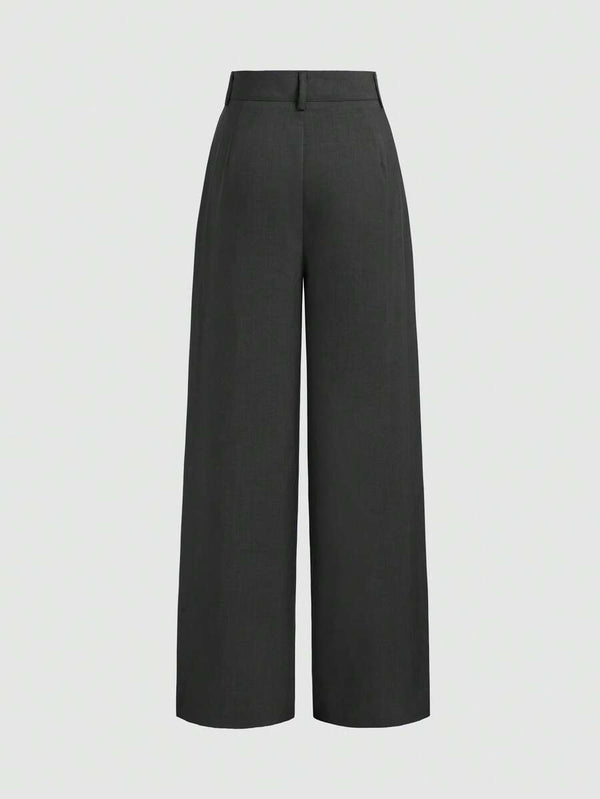 Detalle del bolsillo y las pinzas frontales de un pantalón de vestir negro.