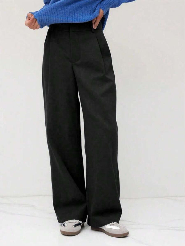 Vista inferior de las piernas anchas de un pantalón formal color negro.