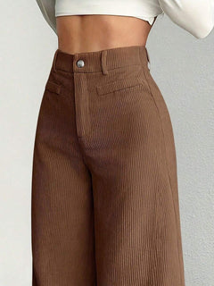 Vista frontal de un pantalón de pana marrón de tiro alto en una modelo.