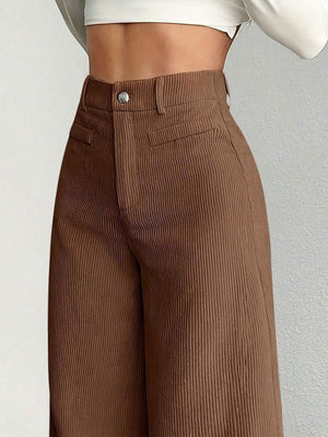 Vista frontal de un pantalón de pana marrón de tiro alto en una modelo.