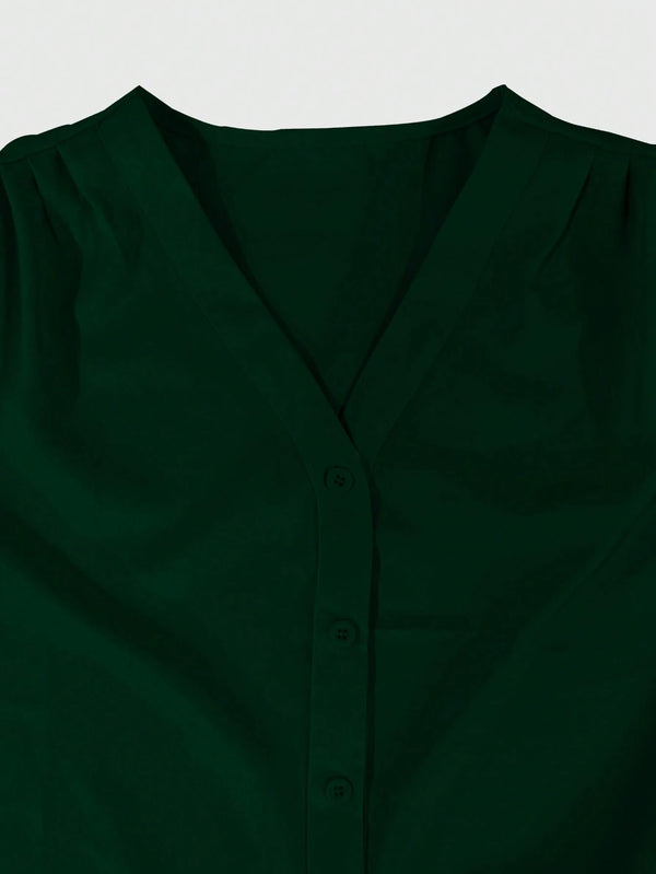 [Acercamiento al cuello en V y botones de la blusa verde oscuro elegante.]