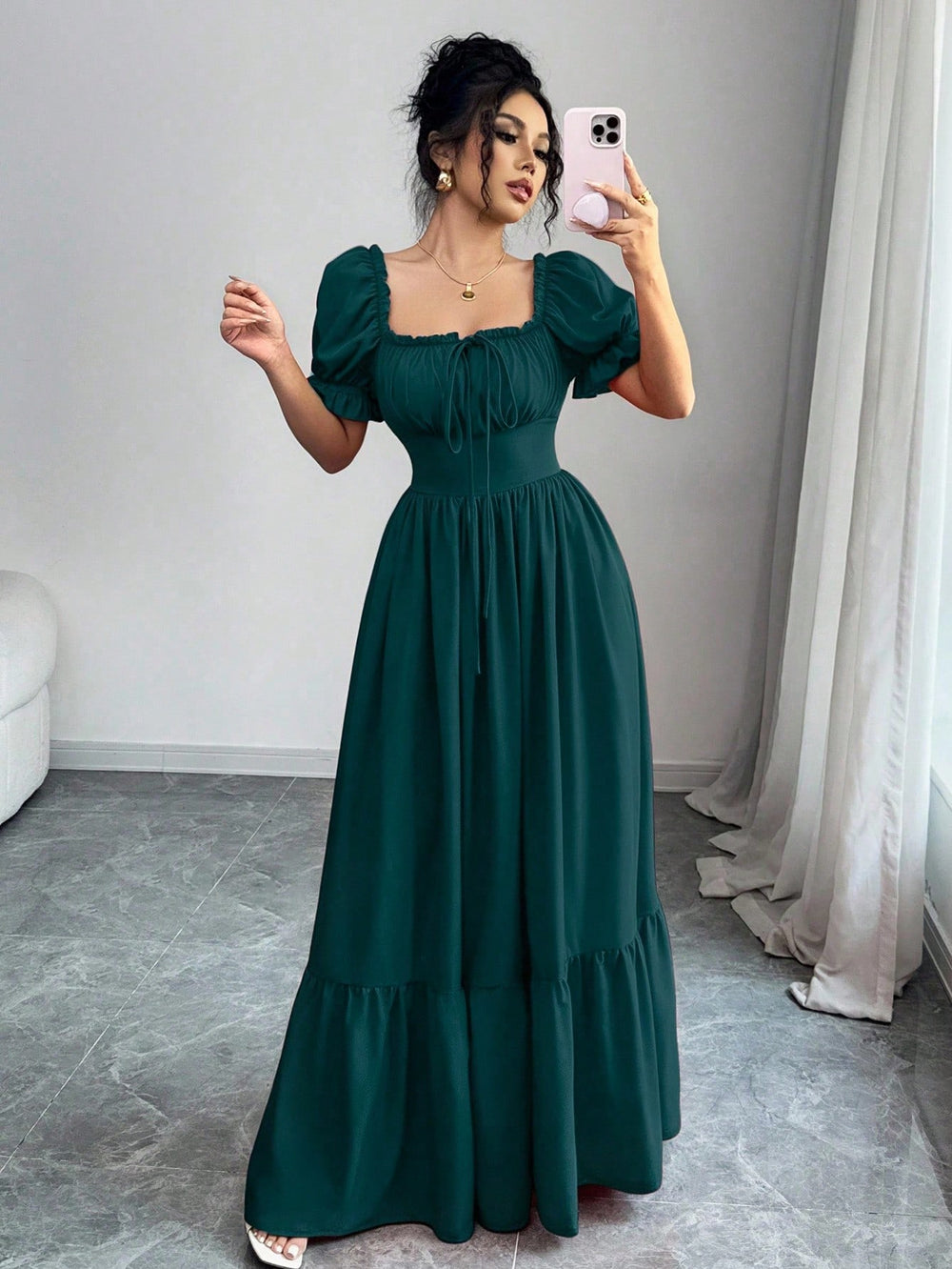 Mujer con vestido largo verde oscuro con escote cuadrado y manga farol.