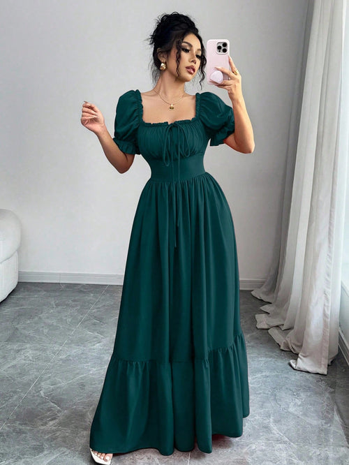 Mujer con vestido largo verde oscuro con escote cuadrado y manga farol.