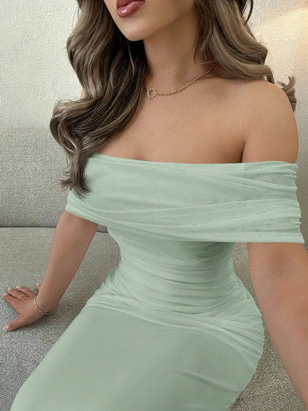 Detalle de la falda maxi y fluida de un vestido formal en tono verde menta.