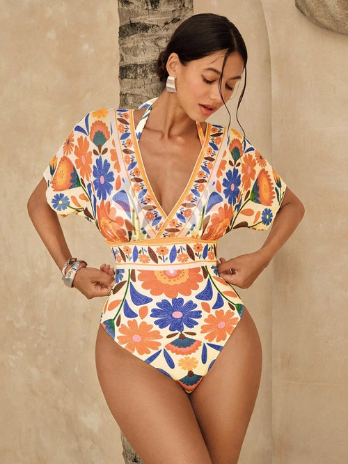 Vista frontal de un traje de baño entero con estampado floral multicolor, mangas cortas y escote en V profundo.