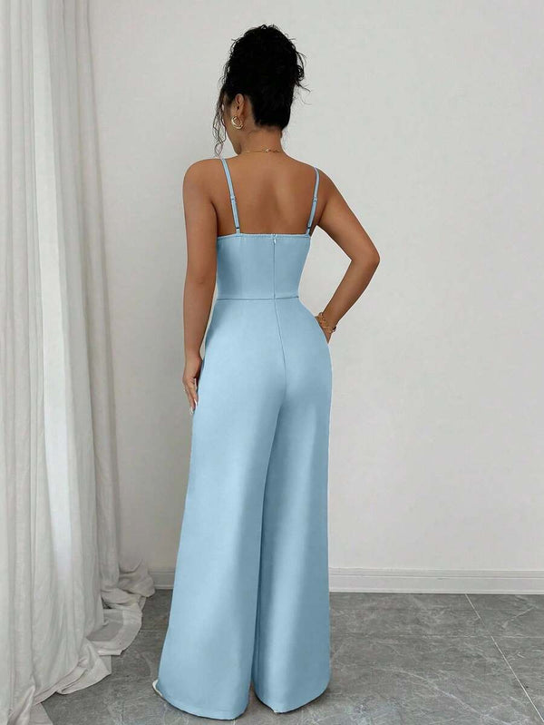 Vista de cerca del escote cruzado y cintura definida de un jumpsuit azul cielo.