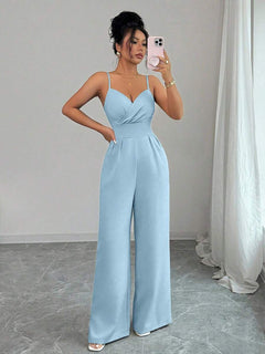Mujer vistiendo un jumpsuit elegante de tirantes finos color azul cielo.