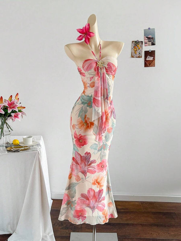 Parte superior de un vestido largo floral en un maniquí, destacando el cuello halter y el busto drapeado.