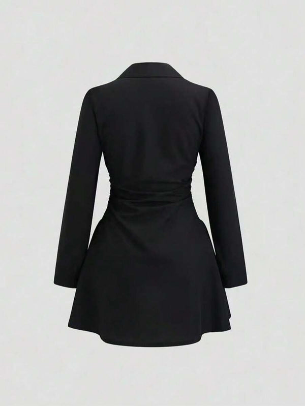 Parte inferior del vestido camisero negro mostrando el corte campana y la fila de botones.