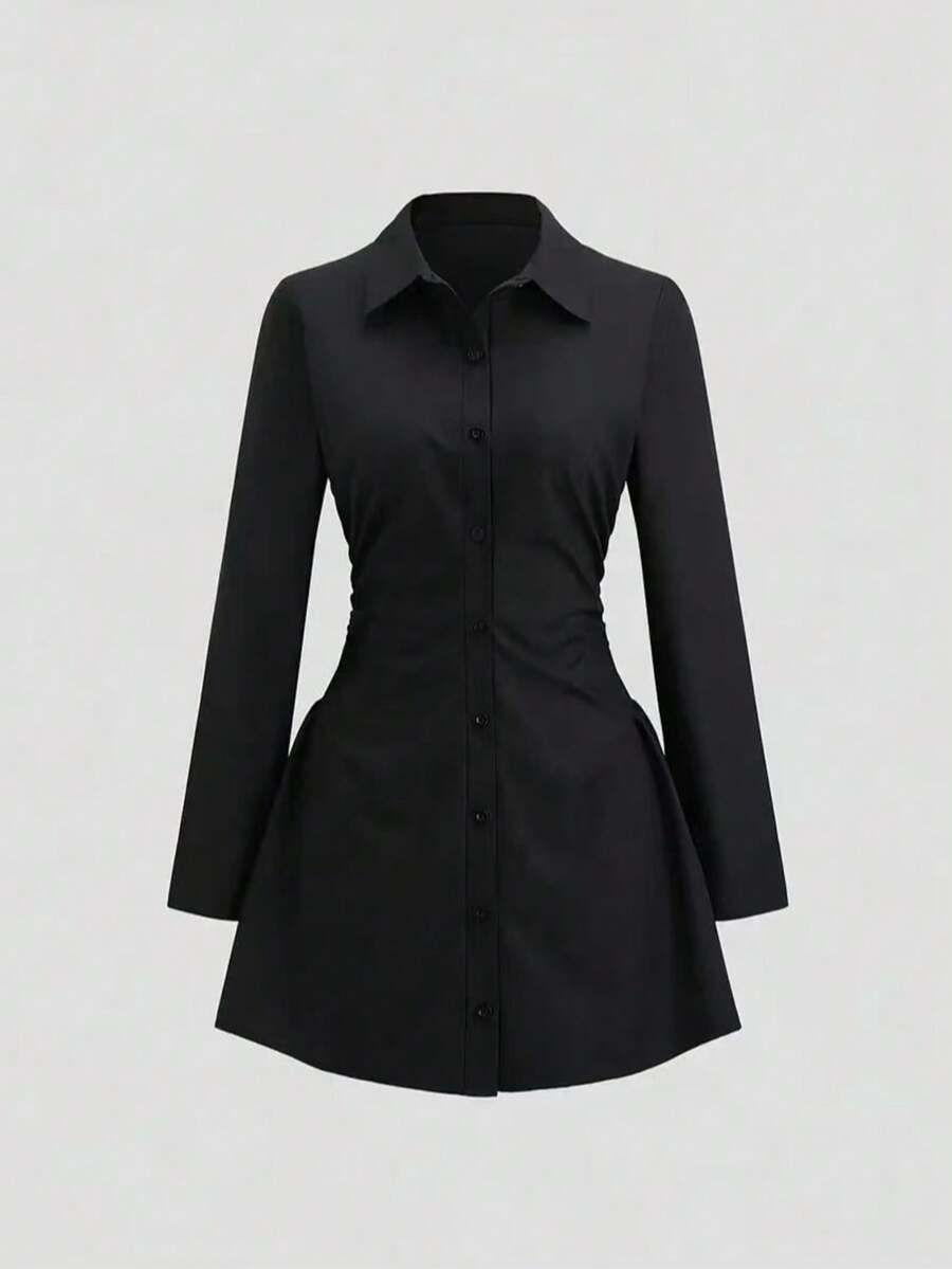 Vestido camisero negro de manga larga con cintura fruncida visto de frente.