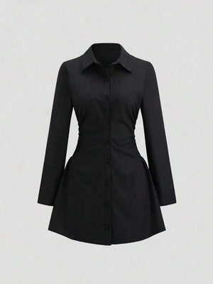 Vestido camisero negro de manga larga con cintura fruncida visto de frente.