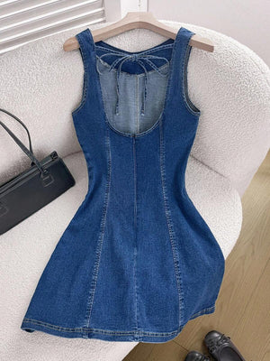 Detalle del escote y la parte superior de un vestido de mezclilla sin mangas.