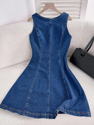 Primer plano de la falda evasé de un vestido de mezclilla con costuras verticales.