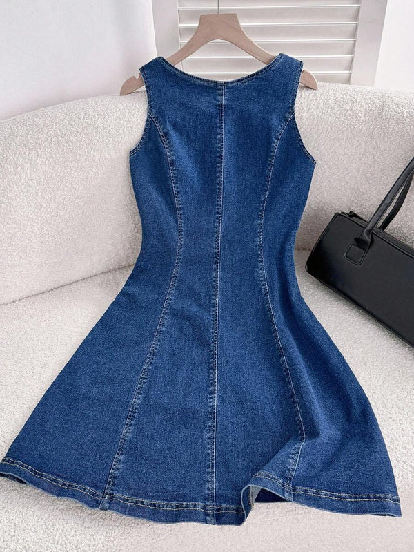 Primer plano de la falda evasé de un vestido de mezclilla con costuras verticales.