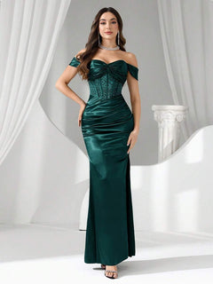 Vista completa de una modelo luciendo un vestido de noche largo verde esmeralda con hombros descubiertos y corsé.