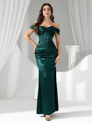 Vista completa de una modelo luciendo un vestido de noche largo verde esmeralda con hombros descubiertos y corsé.